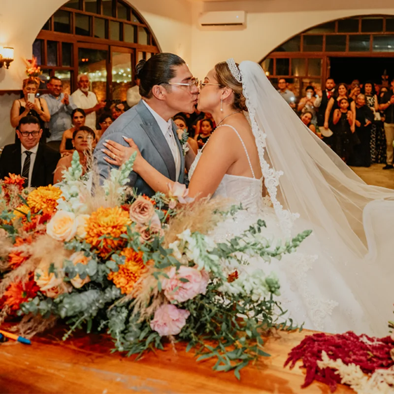 Couple kissing in front of a white chapel at blue hour