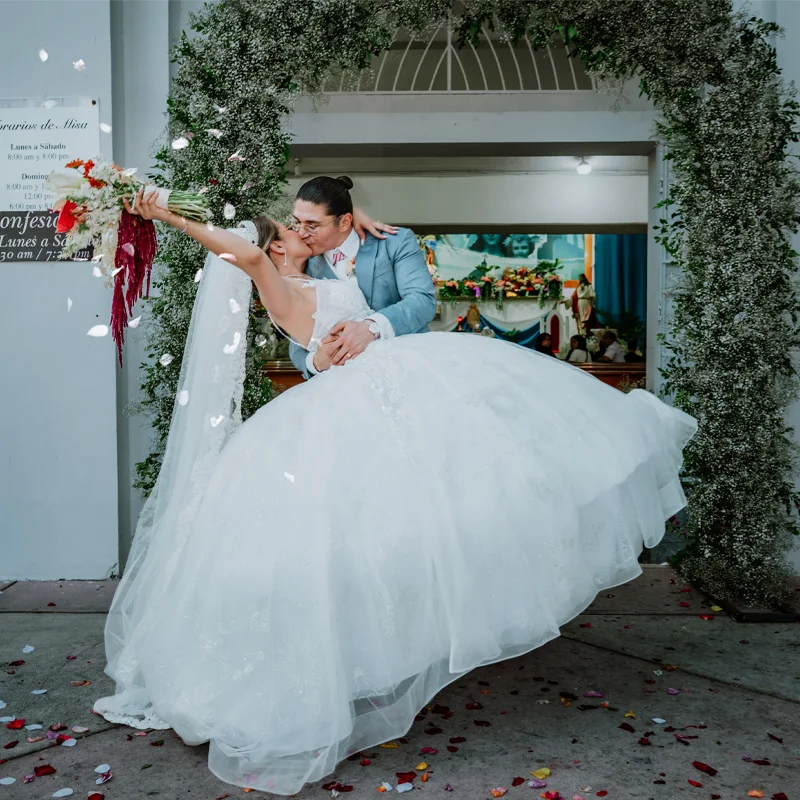 Ceremony kiss behind an autumn floral arrangement