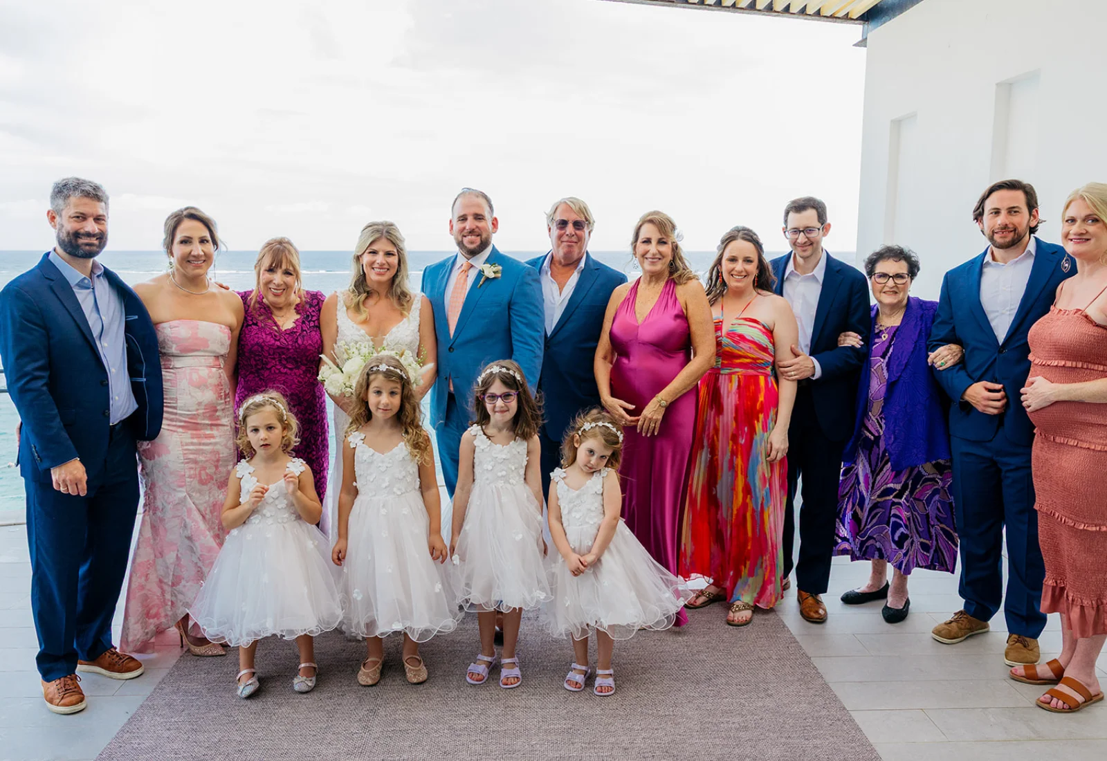 Elegant beachfront wedding ceremony with heart gesture and turquoise ocean view